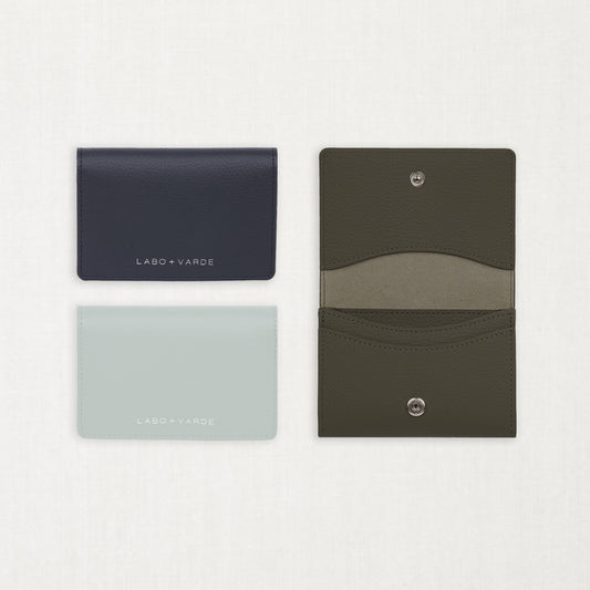 Labovarde Business Card Holder — Flat lay view of closed navy and clear blue cases next to an open etoupe holder showing leather detail on a white background