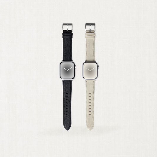 Two minimalist Labovarde Apple Watch bands made of sustainable corn-based bio-leather in black and warm beige, displayed side-by-side on a light neutral background