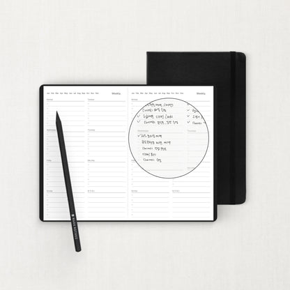 Labovarde Business Diary in Black — Flat lay view of an open weekly planner with handwritten notes and a pencil