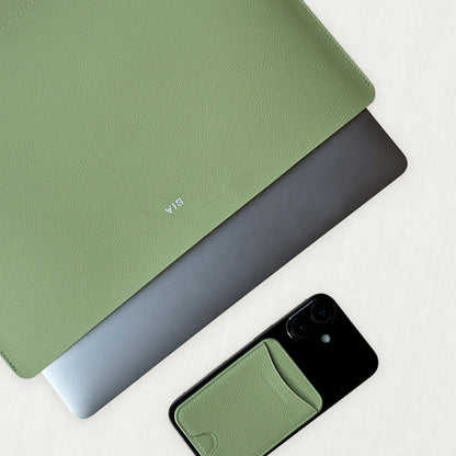 Labovarde Laptop Sleeve in Sage-Green — Flat lay view of a silver laptop inside the sleeve next to a iPhone
