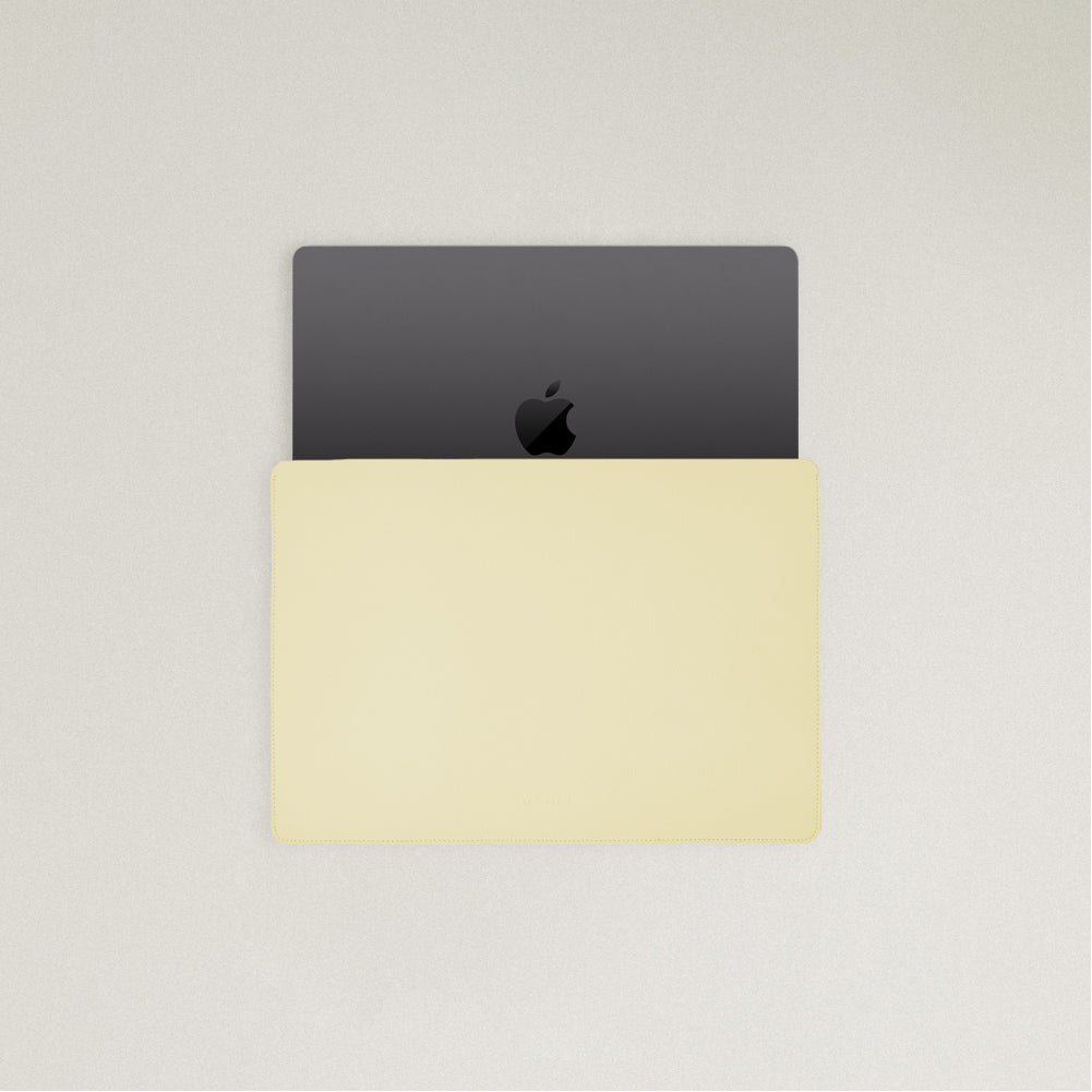 Labovarde Laptop Sleeve in Light Yellow — Top view with a space gray MacBook partially inserted to show the sleek fit
