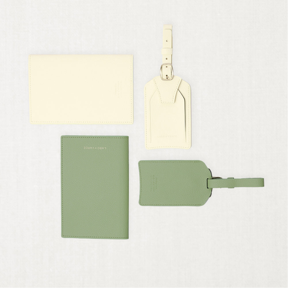 Labovarde Passport Cases and Name Tags — Flat lay view of matching light yellow and sage green travel sets on a white background